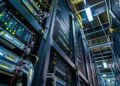 This photograph showcases a bustling server room at the heart of digital infrastructure. The blue and green ambient lighting highlights rows of servers lined with numerous cables and components. These machines are crucial for data storage, management, and computation, facilitating everything from everyday internet browsing to complex cloud computing tasks. Efficiently organized, each server is equipped with advanced technology to ensure optimal performance and security, vital for the operation of countless businesses and services around the globe.